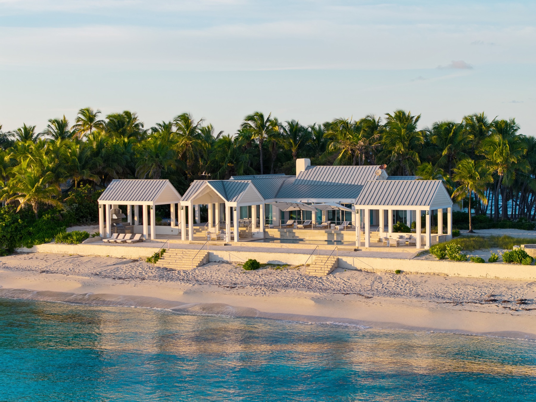 Beachfront estate at golden hour, aerial