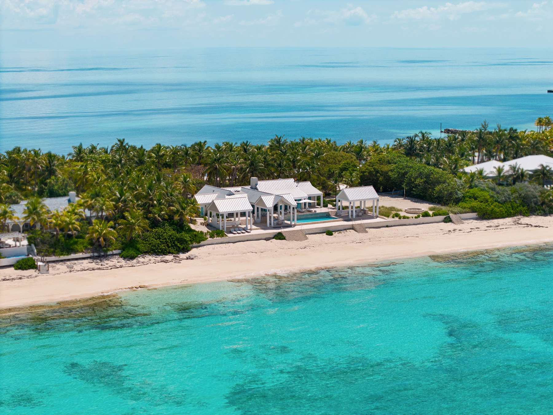 Aerial of villa and pool over coral reef