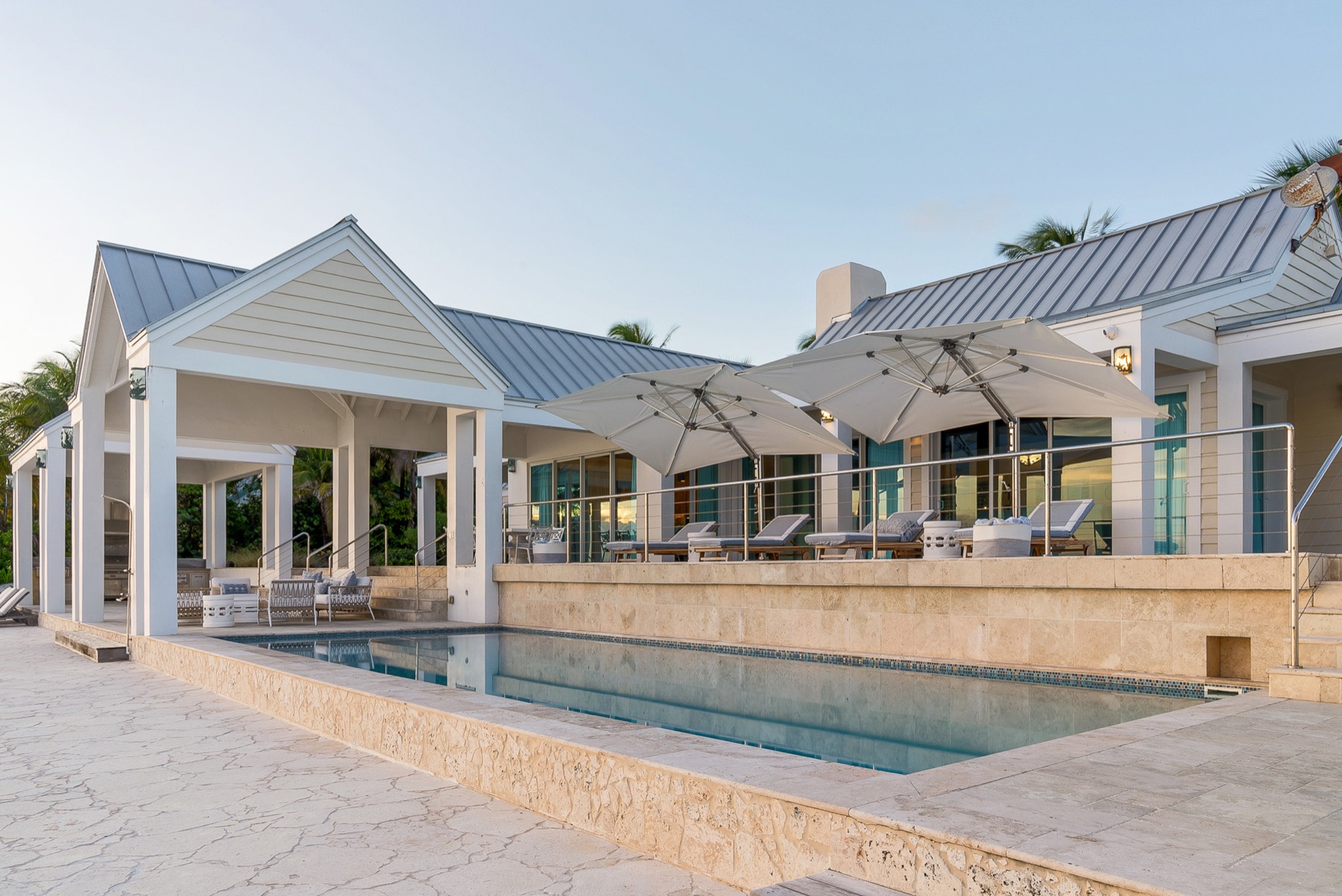 Pool terrace with cantilevered umbrellas at dusk